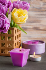 Obraz na płótnie Canvas Purple yellow tulip flower, lit candles