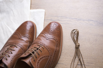 classic brown leather shoes on wooden floor