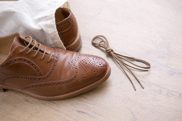 classic brown leather shoes on wooden floor