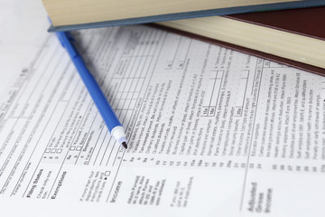 individual income tax return form and books reports on office work desk