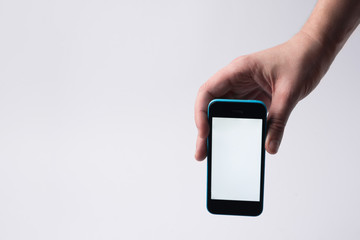 Man holding mobile phone with blank screen on white background