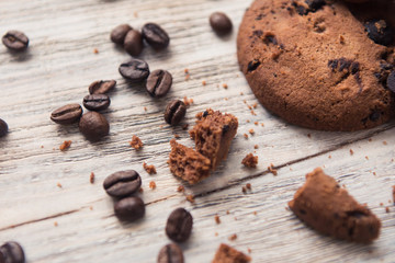 broken chocolate chip cookies with coffee beans on white wooden table