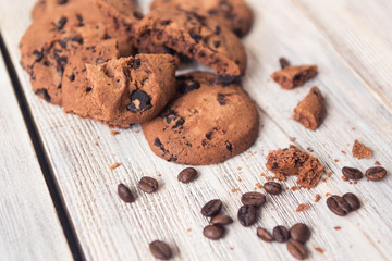 broken chocolate chip cookies with coffee beans on white wooden table