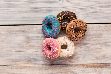 glazed donuts with sprinkles on a white wooden table