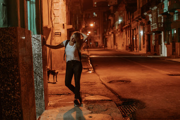 night scene on an orange lit street in the middle of the night in the cuban city Havana, all shot in a lovely atmosphere, lit by the street lights