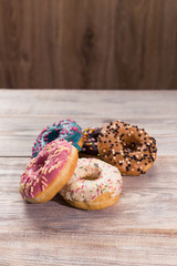 glazed donuts with sprinkles on a white wooden table