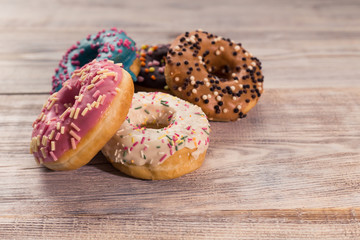 glazed donuts with sprinkles on a white wooden table