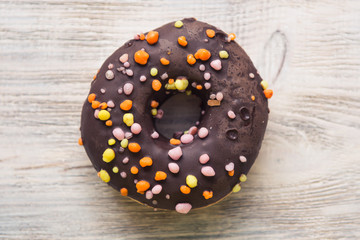glazed donuts with sprinkles on a white wooden table