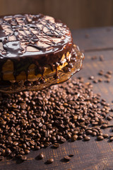 icing biscuit cake soaked in cream on a dark wooden table with coffee beans