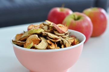bowl of sun dried apple chips and fresh apples in the background, homemade healthy snack - 191789450
