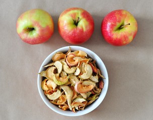 bowl of sun dried apple chips and fresh apples in the background, homemade healthy snack