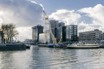 Skyline of Rotterdam in clowdy day in November as seen from old harbor with vintage ships illustrating modern urban landscape with water, ships and modern buildings, Rotterdam, Netherlands.