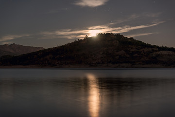 Night landscape view of full moon over lake.