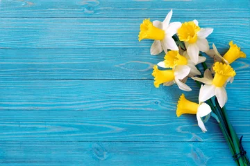 Deurstickers Narcis Narcissenboeket op blauwe houten tafel