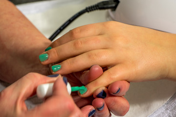 Child getting her nails painted in a salon