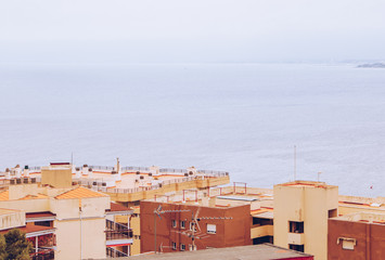 View of bright houses and roofs. Sea background