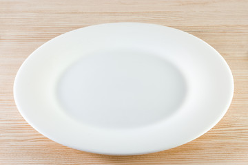 white plate isolated on wooden table background