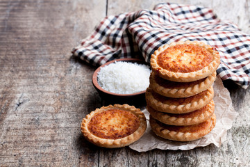 Stack  of coconut tarts on wooden table