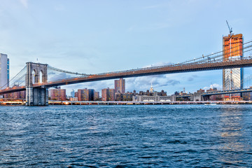View of outside outdoors in NYC New York City Brooklyn Bridge Park by east river, cityscape skyline during sunset, construction skyscraper