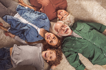 Top view portrait of cheerful bearded grandfather, outgoing grandma, beaming lady and glad son...