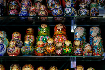 Fototapeta premium A lot of Matryoshka at souvenir market shop. Different colors Russian dolls. Traditional classic Russian handicraft art background. Famous classical and modern Russian dolls Matryoshka toys