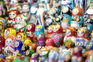 Fototapeta na wymiar A lot of Matryoshka at souvenir market shop. Different colors Russian dolls. Traditional classic Russian handicraft art background. Famous classical and modern Russian dolls Matryoshka toys