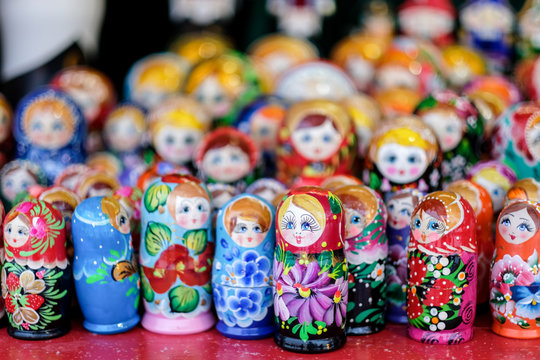 A lot of Matryoshka at souvenir market shop. Different colors Russian dolls. Traditional classic Russian handicraft art background. Famous classical and modern Russian dolls Matryoshka toys