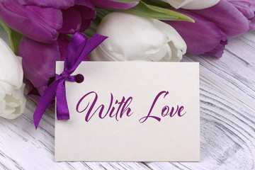 Valentines day greeting card, tulips white purple ribbon, white wooden background.