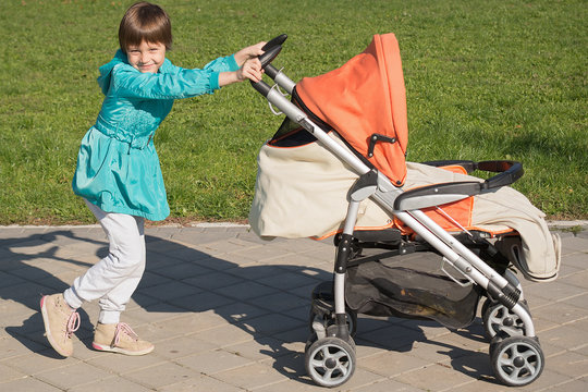 sister walking with young brother in stroller