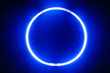 round glow stick of blue color/ Background from a round glow stick of blue color like neon on a black board