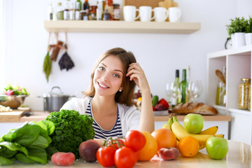 Young woman standing near desk in the kitchen. Young woman .