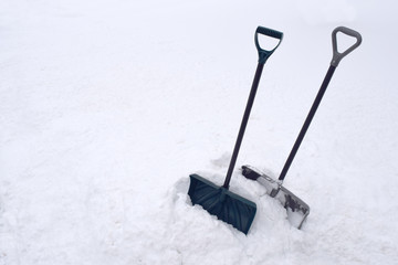 Snow Shovels in Snow Pile During Cold Winter White Snowstorm