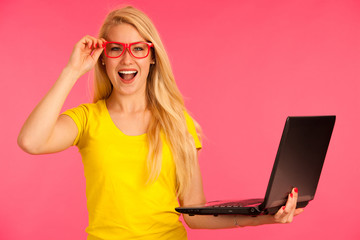 Beautiful young woman holds a laptop gesture surprise and success isoalted