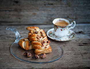 Danish pastry maple pecan with nuts and a cup of coffee, breakfast