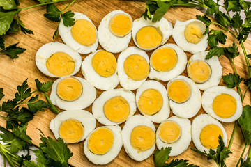 Boiled eggs cut in halves decorated with fresh parsley leaves