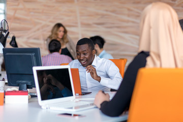 Fototapeta premium Frustrated young african entrepreneur with sad grimace in front of his laptop in office