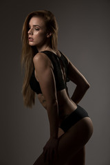 Fototapeta premium Boudoir photography of a beautiful young woman over dark background