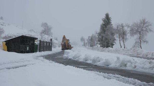 Vehicle shot on backhoe loader clean the snow