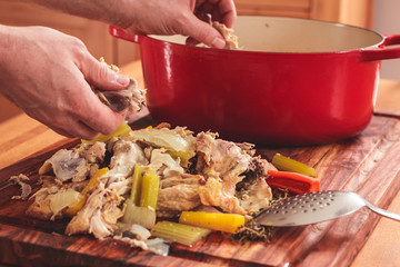 Separating the meat from the bones of leftover roasted chicken carcass.