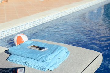 Fototapeta na wymiar Using mobile smartphone on sunny holiday by swimming pool outdoors background. Close up view photo of leisure luxury lifestyle