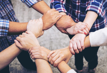 close up hand of business partnerships people crossed hands  finishing up meeting showing unity over office desk , business teamwork concept