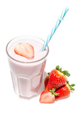 Strawberry next to a glass of strawberry yogurt close-up isolated on a white background