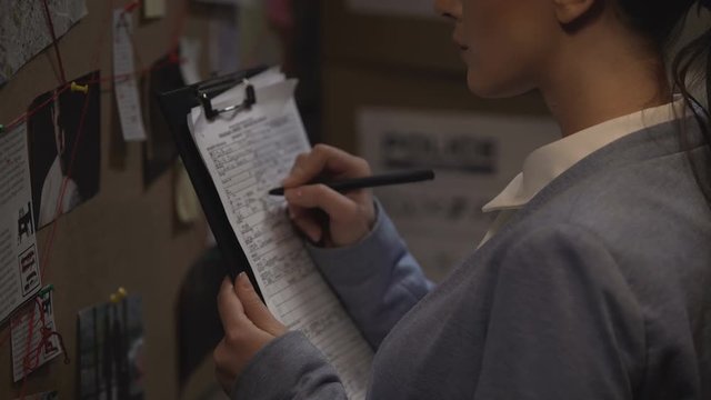 Criminal investigator drawing up record, writing down case details, inquiry