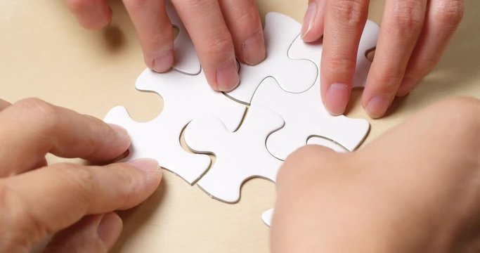 Team completing white puzzle together