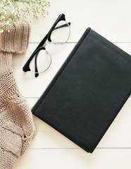 Notebook and glasses on wooden white background