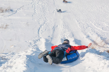 Children ride on tubing. Winter entertainment. Skiing in the winter. Snowy fun in the winter. Fun in the winter. Tubing.