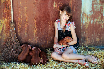 The girl is playing with red newborn pigs of the Duroc breed. The concept of caring and caring for animals.