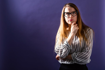 Fototapeta premium Young woman in a thoughtful pose on a solid background