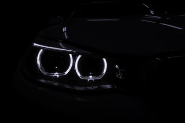 Fototapeta na wymiar Modern car with backlight on black background. Exterior detail.
