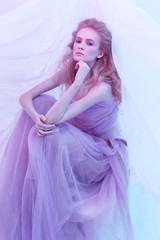 Fototapeta premium Fashion portrait of young beautiful woman in fluffy violet dress.